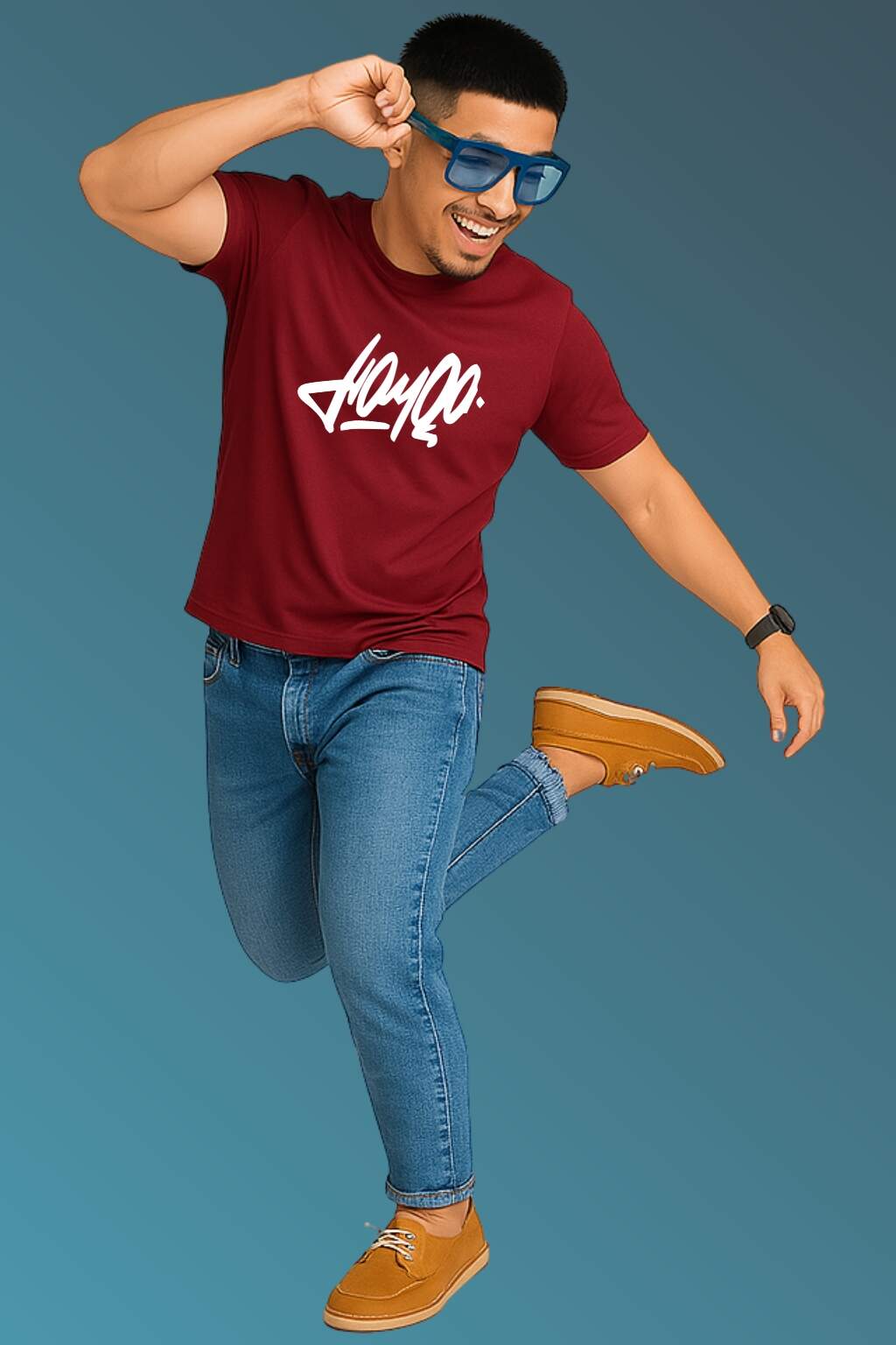 t-shirt featuring bold black stylized typography, worn with blue denim jeans and brown casual shoes. Set against a smooth blue gradient backdrop, the photo highlights modern streetwear style in a minimal, fashion-forward composition."