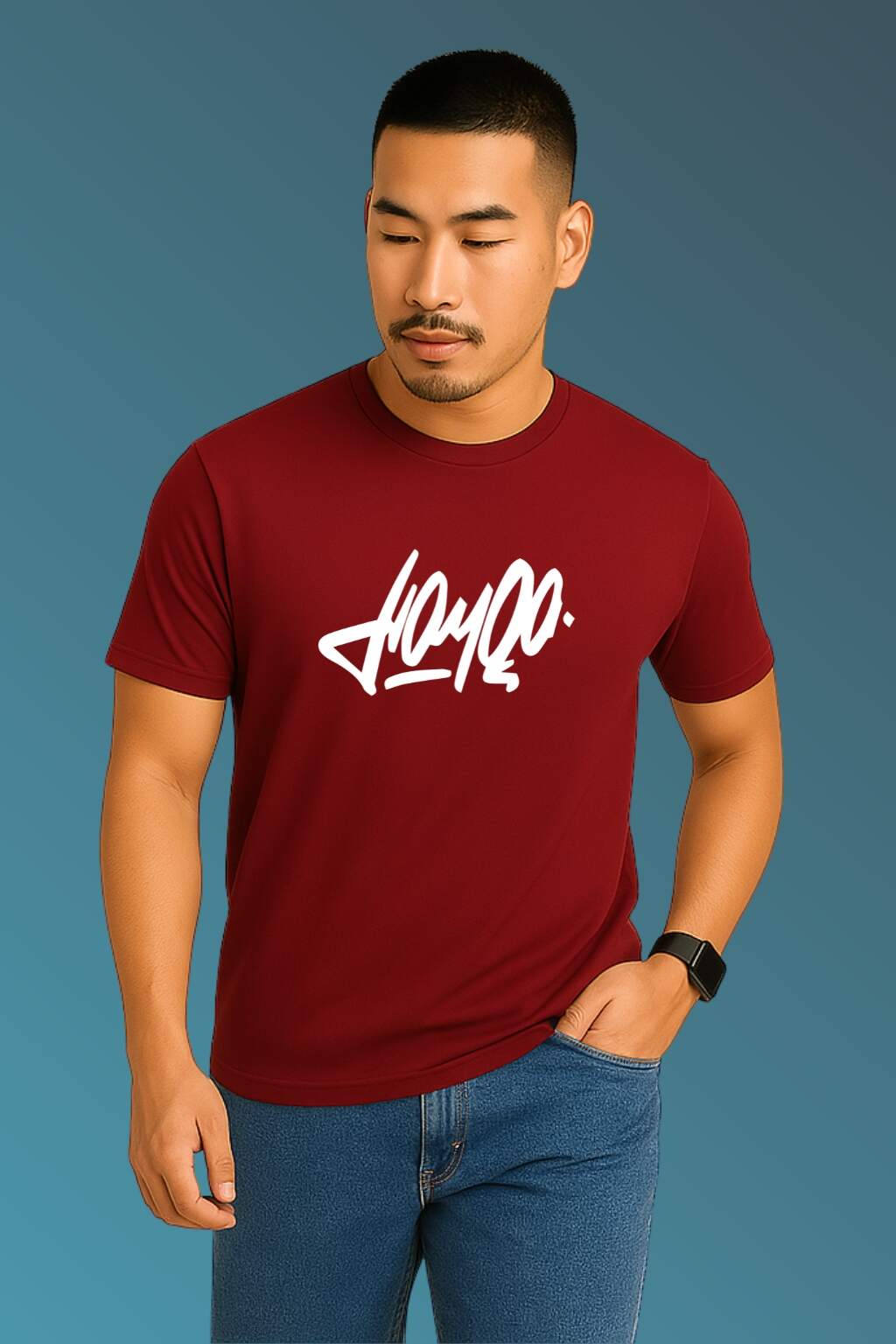 t-shirt featuring bold black stylized typography, worn with blue denim jeans and brown casual shoes. Set against a smooth blue gradient backdrop, the photo highlights modern streetwear style in a minimal, fashion-forward composition."