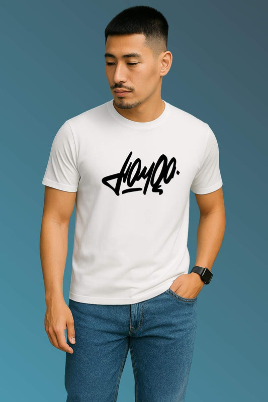 t-shirt featuring bold black stylized typography, worn with blue denim jeans and brown casual shoes. Set against a smooth blue gradient backdrop, the photo highlights modern streetwear style in a minimal, fashion-forward composition."